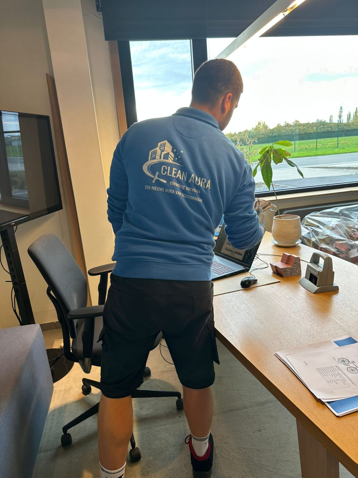 Clean Aura medewerker onderhoudt een kantoorruimte